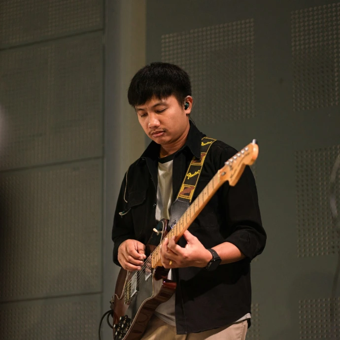 Young man playing electric guitar on stage